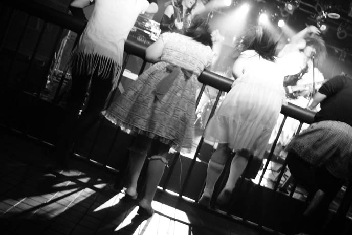 Japanese gothic lolita headbanging, visual kei fans rocking out at j-rock concert in Tokyo, Japan. Fan girls jumping, swinging hair.