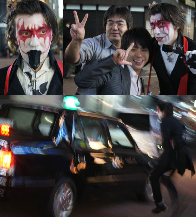 Batman makeup, red bat eyeshadow. Joker and Batman Goth costume for Halloween. Joker running after taxi, funny walk. Black rose, Japanese businessmen giving v-fingers posing for photos.