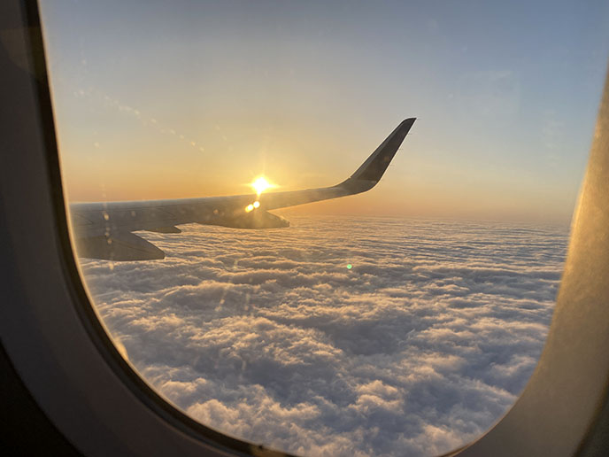 airplane wing sunset clouds window flight landing