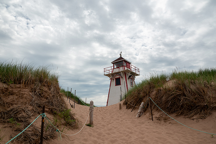 The Covehead Harbour Lighthouse covehead Bay. beach sand lighthouse red white